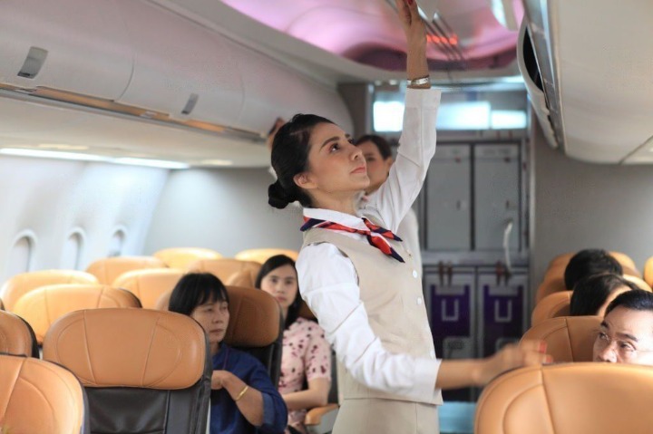 Air Hostess closing cabin compartment in the airline